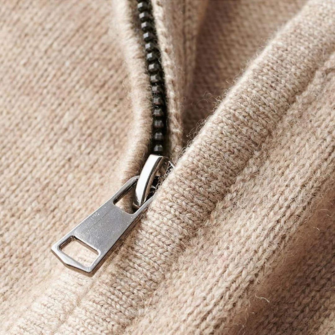 Zbliżenie na metaliczny zamek swetra — miękka dzianina WoolBlend i precyzyjne wykończenie przy półgolfie.