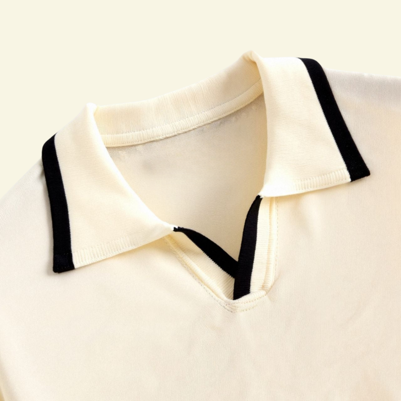 Detal kołnierza kremowej koszulki polo, pokazany na płasko.