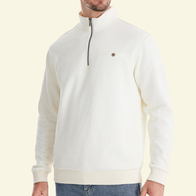 Model w białym swetrze rozpinanym z półgolfem, proste dopasowanie, metaliczny zamek i minimalistyczny detal na piersi.