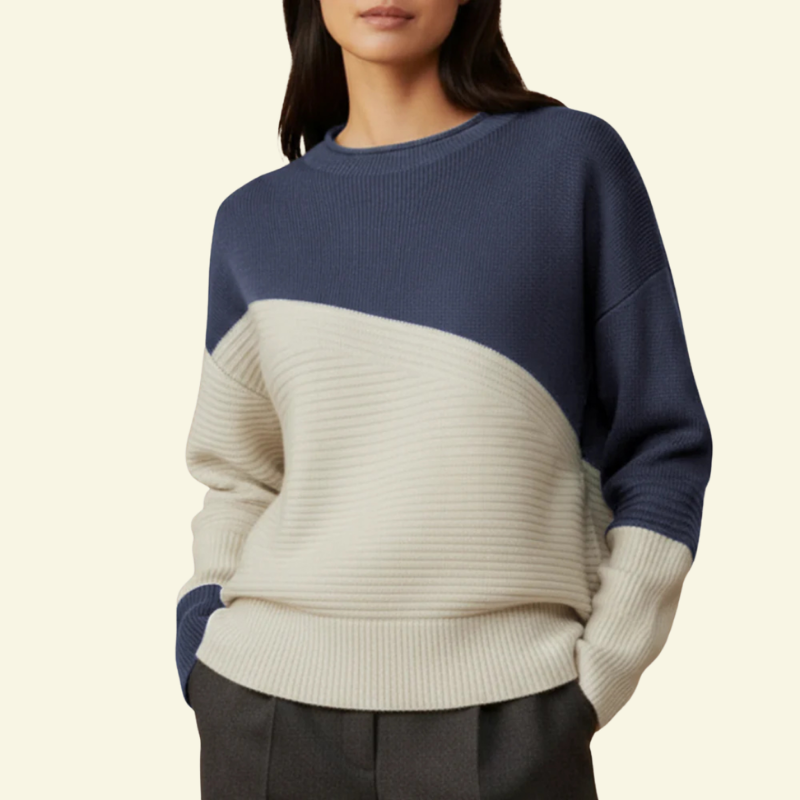 Modelka w swetrze color-block w granacie i kremie; elegancki kontrast, swobodny krój.