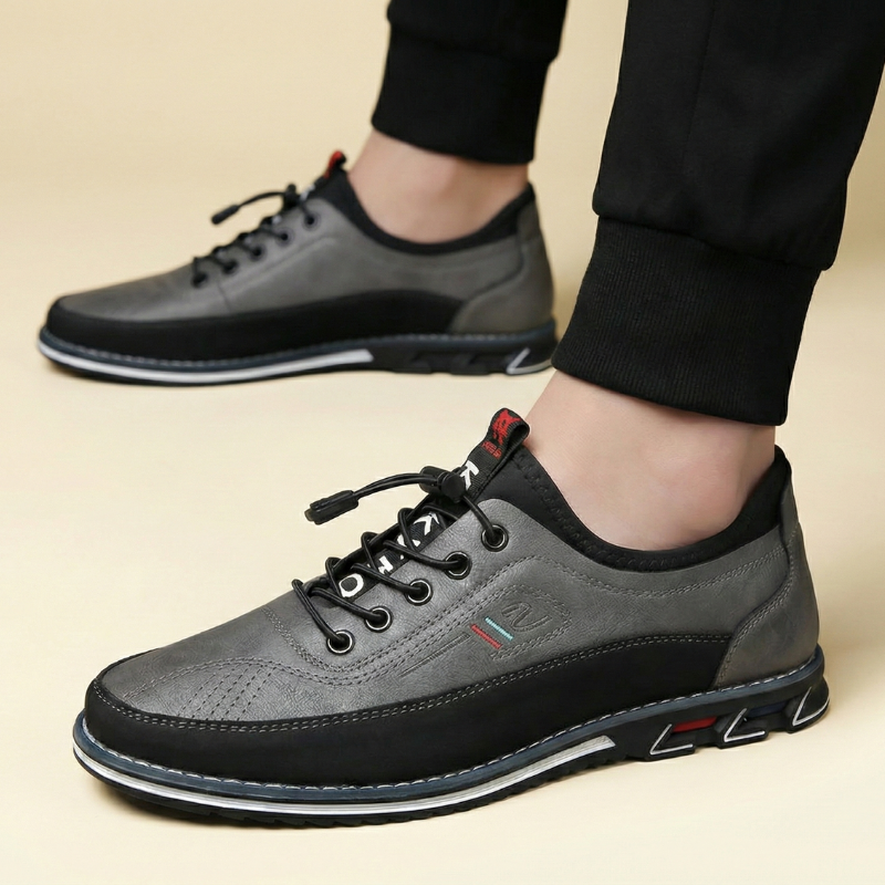 Srebrne sneakersy męskie noszone przez modela, ujęcie boczne na stopach, prezentujące metaliczne wykończenie cholewki w stylizacji casualowej.