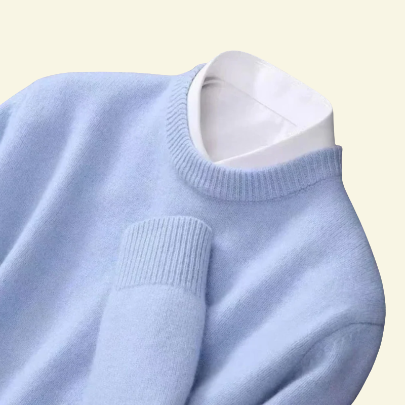 Zbliżenie na kołnierz jasnoniebieskiego swetra z widoczną białą koszulą pod spodem.