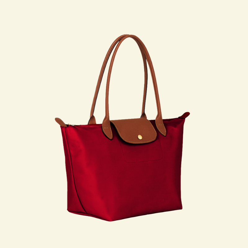 Czerwona torebka na ramię z nylonu i skóry naturalnej, uchwyty i klapka z brązowej skóry, ujęcie z lekkiego boku — Lubomirske