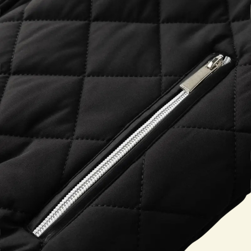 Detal kieszeni czarnej kurtki z metalowym, srebrnym zamkiem błyskawicznym osadzonym w pikowanej tkaninie.