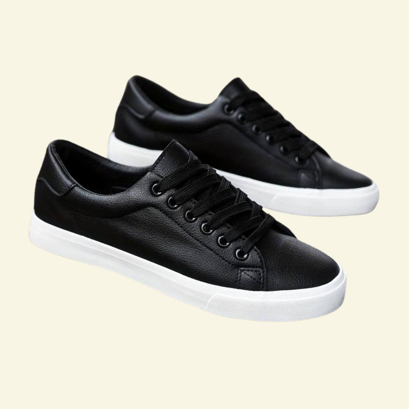 Czarne niskie sneakersy męskie o minimalistycznej formie, wykonane ze skóry ekologicznej, prezentowane na jasnym tle z widoczną białą podeszwą.