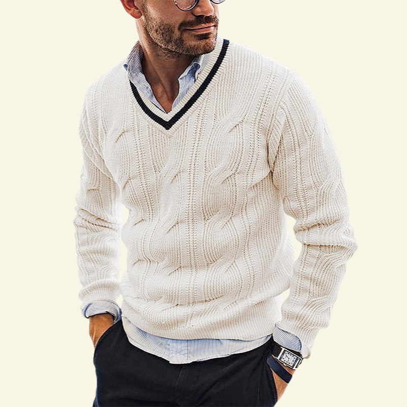 Model w kremowym swetrze w serek ze splotem warkoczowym; jasny odcień podkreśla strukturę dzianiny.