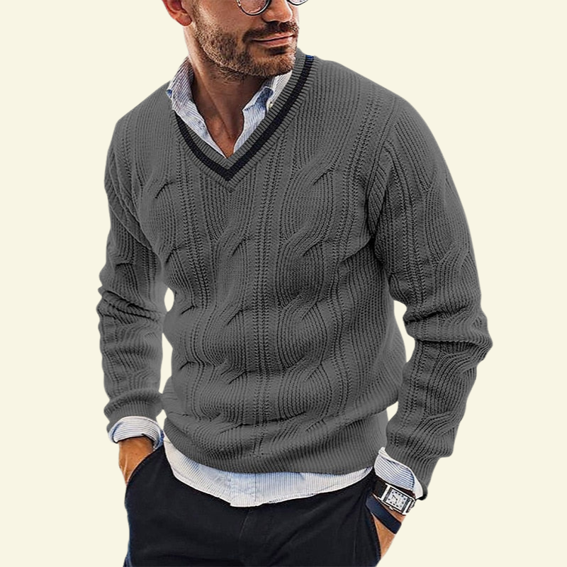 Model w szarym swetrze w serek; neutralny kolor akcentuje klasyczny kabelkowy splot.