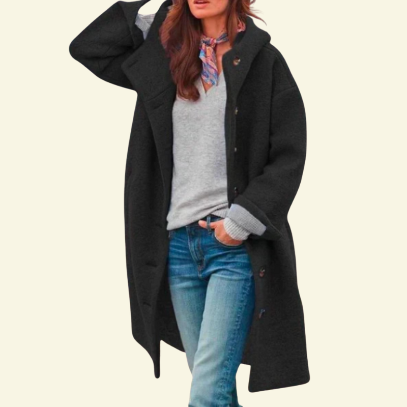 Modelka w czarnym długim płaszczu, ujęcie na stojąco.