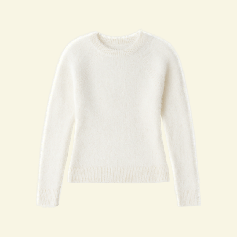 Biały damski sweter o mohairowej teksturze w ujęciu flat-lay, lekko puszysty, z okrągłym dekoltem i klasycznym dopasowaniem — minimalistyczna prezentacja w stylu Lubomirske.