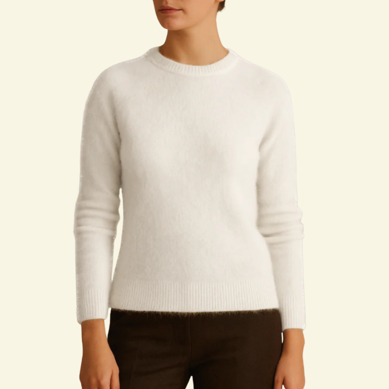Modelka w białym mohairowym swetrze o klasycznym kroju, przód widoczny w naturalnym świetle — elegancka, subtelnie puszysta struktura.