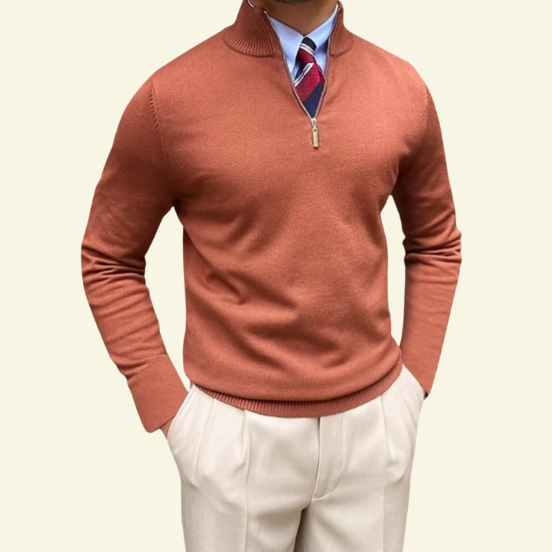 Model w ceglastopomarańczowym swetrze rozpinanym z półgolfem, ciepły odcień i miękka tekstura Premiumowej Mieszanki Tkanin.