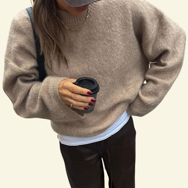 Piaskowy, puszysty sweter o mohairowej fakturze, prezentowany w luźnym oversize — ciepły, miękki i wyrazisty w codziennym stylu.