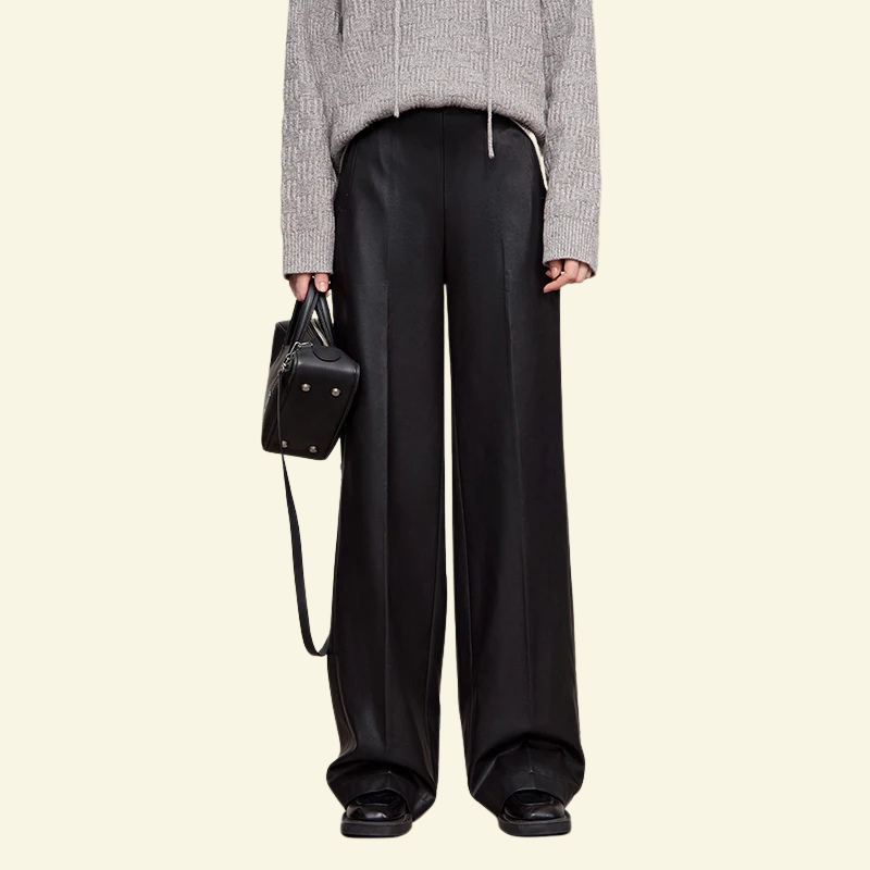 Czarne skórzane spodnie damskie z szerokimi nogawkami, prezentowane na modelce w minimalistycznym stylu — Lubomirske