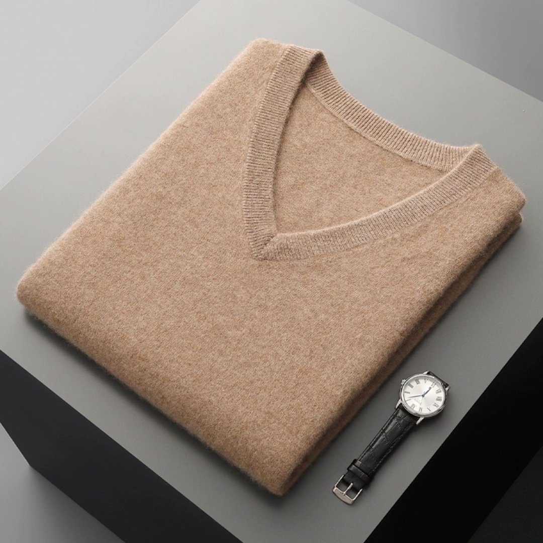 Aesthetic photo of beige wool sleeveless sweater laying on a stand with a watch next to it