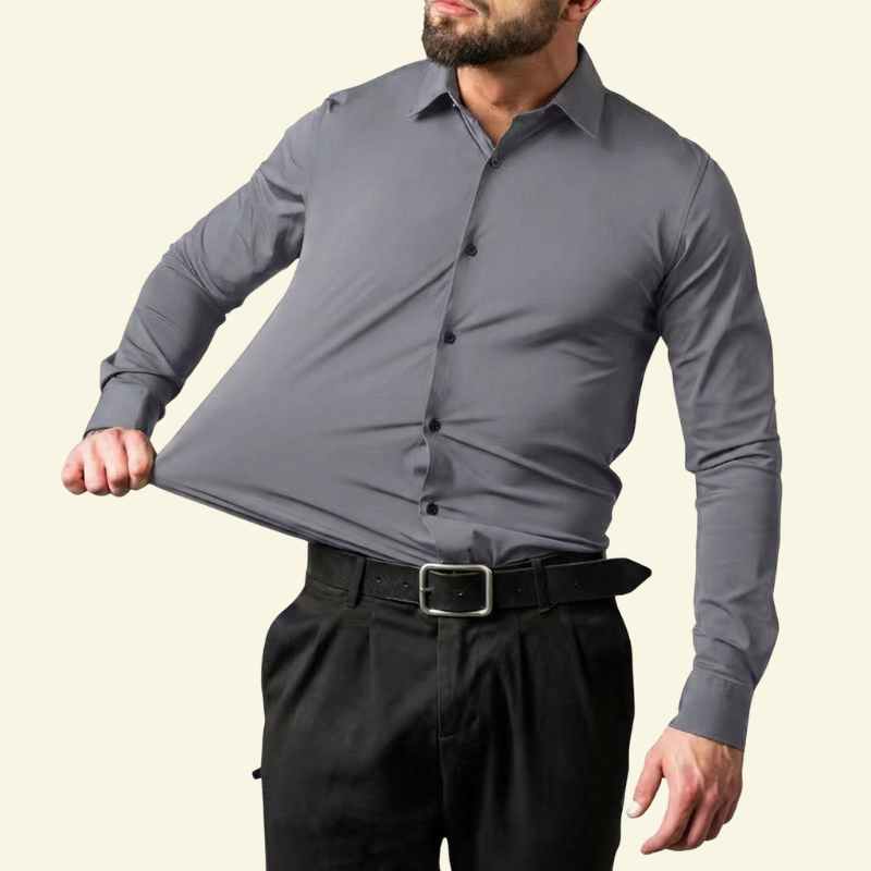 Model rozciągający materiał szarej koszuli w chłodnym odcieniu, ujęcie od przodu.