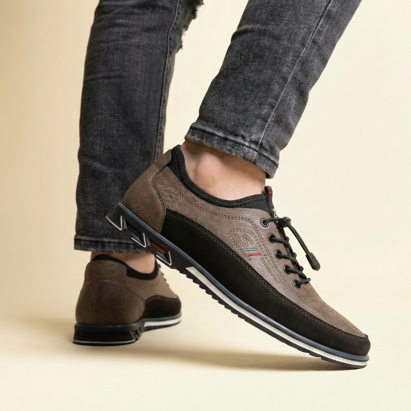 Sneakersy męskie w kolorze beżowo-szarym noszone przez modela, ujęcie na stopach w neutralnej stylizacji casualowej.