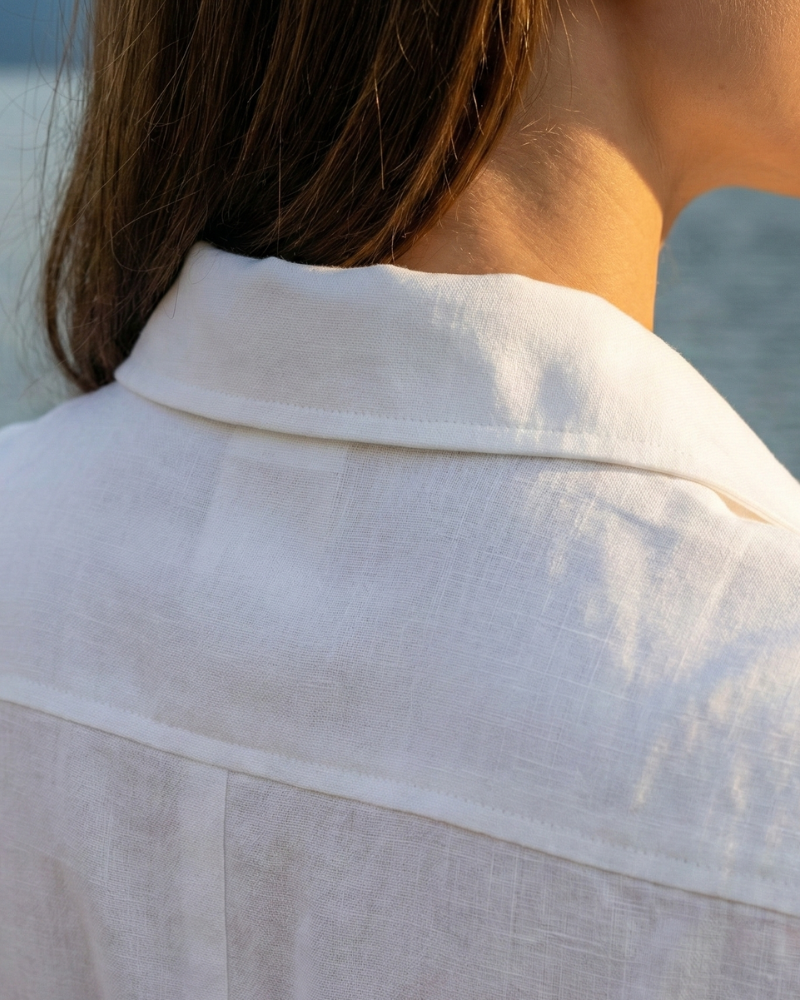 detal kołnierzyka i materiału białej sukienki koszulowej