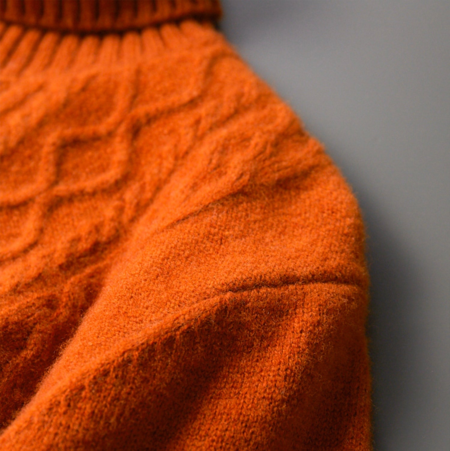Zbliżenie na strukturę wełnianej dzianiny w intensywnym odcieniu pomarańczu — szlachetny charakter materiału — Lubomirske