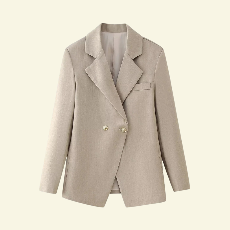 Kremowa marynarka ułożona na jasnym tle, dwurzędowe guziki i szerokie klapy.